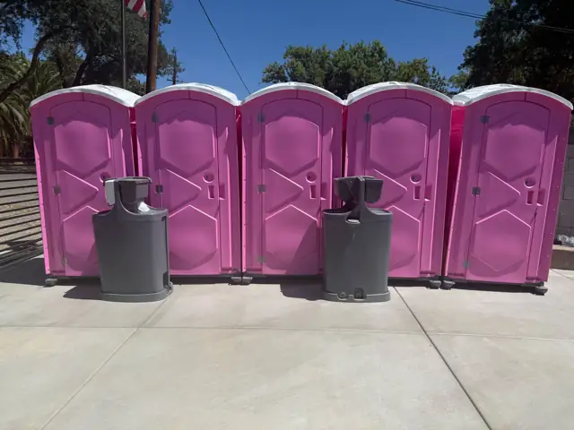 Row of event porta potties with hand-wash stations