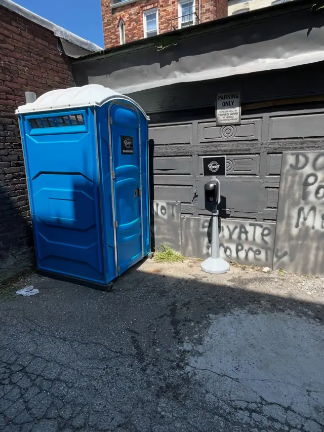 Porta potty set behind a commercial building